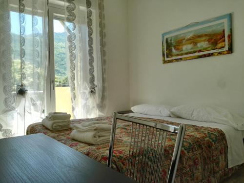 a bedroom with a bed and a window and a table at Hotel Paradise in Bruzolo