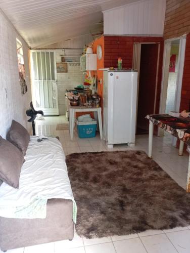 a living room with a couch and a refrigerator at Chácara Encanto do Luar casa de 2 quartos in Rio Bonito