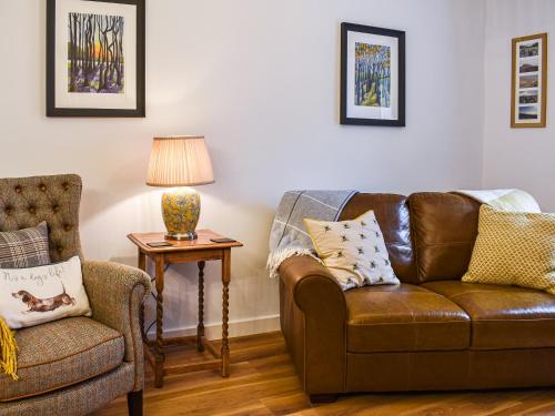 ein Wohnzimmer mit einem braunen Sofa und einem Stuhl in der Unterkunft Number 6 Uk33332 in Newby