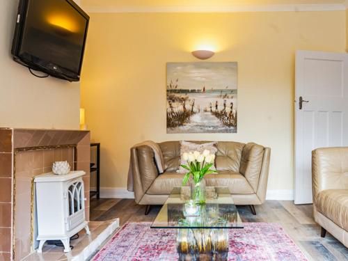 Una sala de estar con un sofá y una chimenea. en Beach House, en Whitley Bay