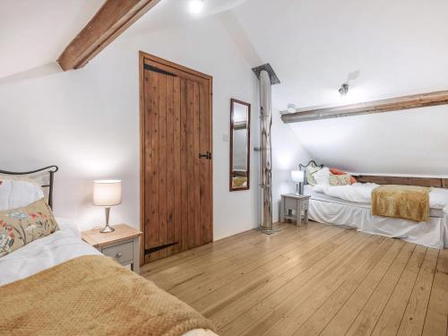 a bedroom with two beds and a wooden floor at John Fanner Barn - Uk37102 in Mellis