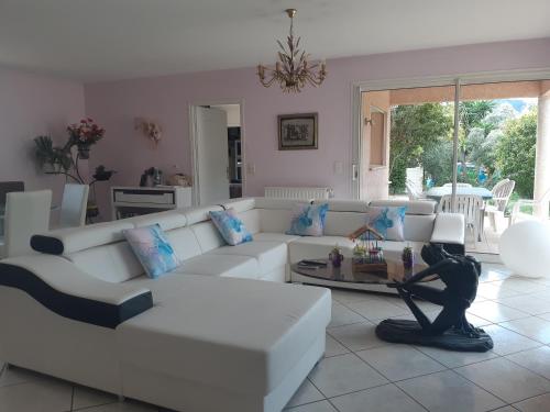 ein Wohnzimmer mit einer weißen Couch und einem Tisch in der Unterkunft Villa de standing avec gd jardin arboré près d'Argelès sur Mer in Saint-André