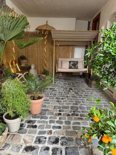 イデンコーベンにあるGemütlich & einzigartig: Altbauloft in Edenkobenの植物とベンチのあるパティオ