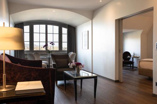 a living room with a couch and a table at Hotel Bellevue Palace Bern in Bern