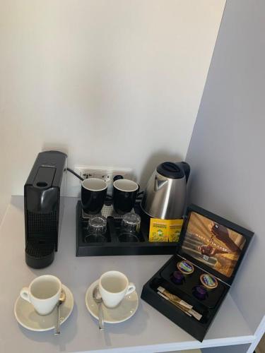a counter with two cups of coffee and a coffee maker at Hotel Fiona Symi in Symi