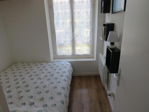 a bedroom with a bed in front of a window at LE GOELAND in Ault
