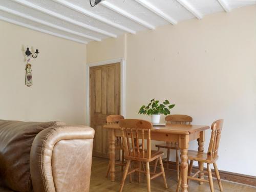 a living room with a wooden table and chairs at Poppy Cottage in Bonsall