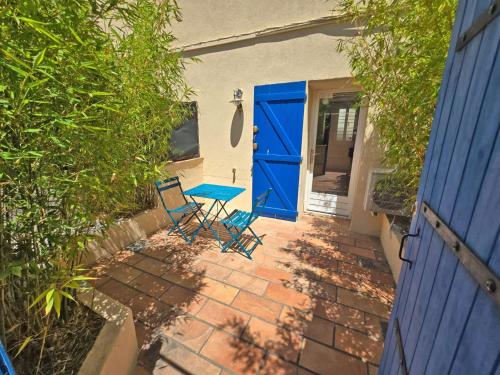 d'une terrasse avec 2 chaises et une porte bleue. dans l'établissement GregBnb - Studio 25m2 - Terasse 30m2 - CLIMATISÉ, à Toulon