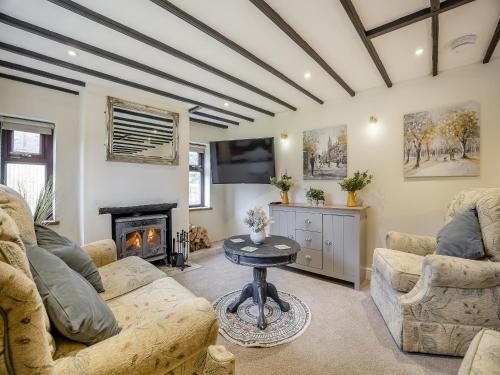a living room with two couches and a fireplace at Huntspill Cottage in Holbeach