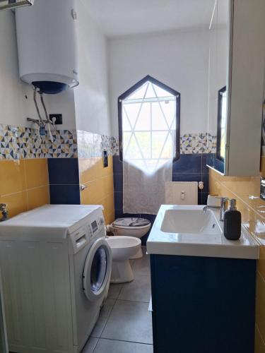 a bathroom with a washing machine and a sink at Mini appartamento vicino al lago in Dormelletto
