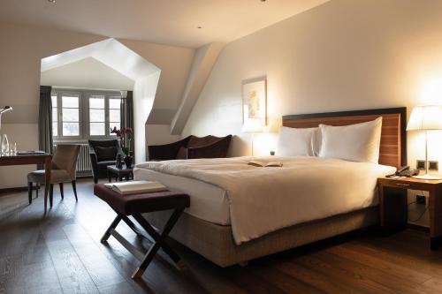 a hotel room with a large bed and a desk at Hotel Bellevue Palace Bern in Bern
