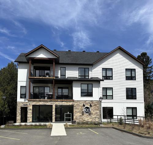a large white building with black windows at Le 800 de St-Jovite in Mont-Tremblant