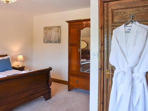 a bedroom with a bed and a robe on a door at Country Lodge in Soulby