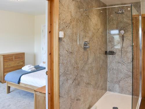 a bathroom with a shower with a glass door at Country Lodge in Soulby