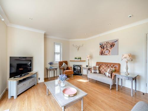 a living room with a couch and a tv at Duck Bay Cottage 1 - Uk43934 in Balloch