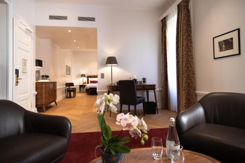 a living room with a couch and a table at Hotel Bellevue Palace Bern in Bern