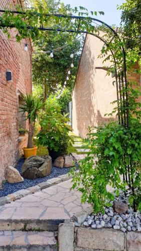 a garden with a stone walkway with trees and plants at GARY Suite - Studio Cosy, Spa et jardin privatif à 4 min de Cambrai in Awoingt
