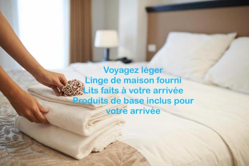 a person is putting towels on a bed at Terrasse sur la Mer in Audierne