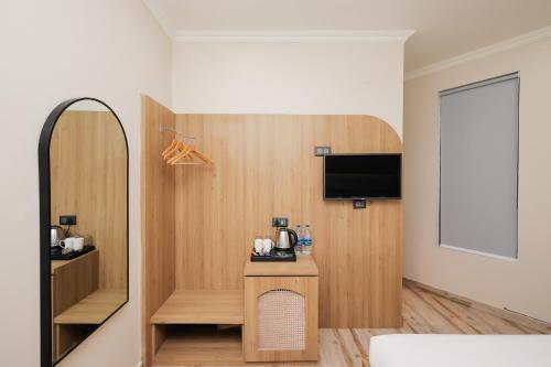 a hotel room with a mirror and a tv at ECKO Tapovan by the Ganges in Rishīkesh