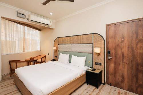 a bedroom with a large bed and a wooden door at ECKO Tapovan by the Ganges in Rishīkesh