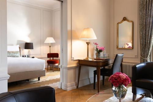 a hotel room with a bed and a desk and a bedroom at Hotel Bellevue Palace Bern in Bern