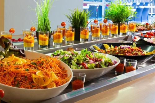 a buffet line with bowls of food and salads at SOWELL HÔTELS Les Jardins du Cap in Cap d'Agde