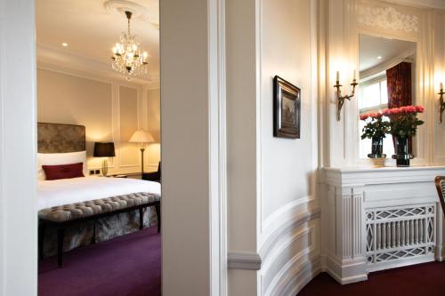 a hotel room with a bed and a mirror at Hotel Bellevue Palace Bern in Bern