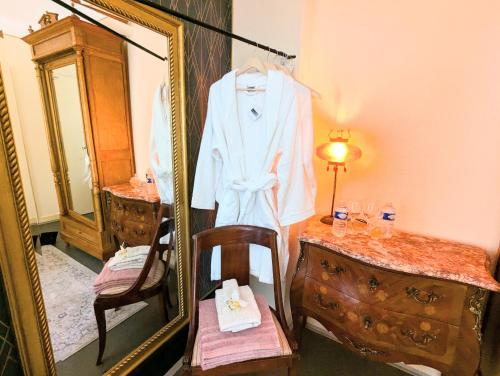 un dressing avec un miroir et un peignoir sur une chaise dans l'établissement Chambres d'hotes la forêt, à Longwy