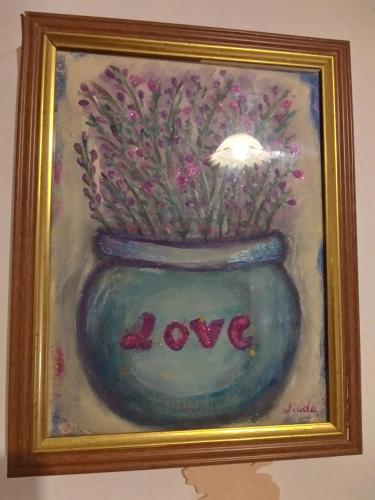 a painting of a vase with flowers in it at Orchidea House in SantʼAntìoco