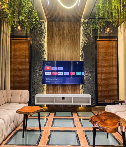 a living room with a flat screen tv on a wall at The White Suites in Karachi