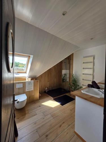 une salle de bains mansardée avec lavabo et toilettes. dans l'établissement Maison familiale chaleureuse à Saint-Évarzec avec terrasse, à Saint-Évarzec