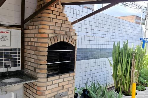 ein Steinofen im Freien auf einer Terrasse mit Pflanzen in der Unterkunft PRAIA POÇO, 150m do mar, piscina, 5 pes, 3 quartos in Ilha da Restinga