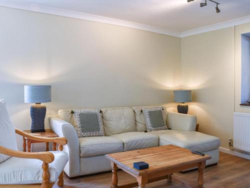 ein Wohnzimmer mit einer Couch und einem Couchtisch in der Unterkunft Swallow Cottage in Gowerton
