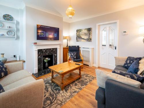 a living room with a table and a fireplace at Fantastic 3-bed home close to Shrewsbury centre - Pass the Keys in Shrewsbury
