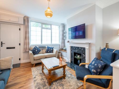 a living room with blue furniture and a fireplace at Fantastic 3-bed home close to Shrewsbury centre - Pass the Keys in Shrewsbury