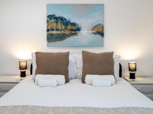 a white bed with pillows and a painting on the wall at Fantastic 3-bed home close to Shrewsbury centre - Pass the Keys in Shrewsbury