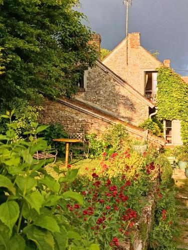 un jardin fleuri devant une maison dans l'établissement Le Relais d'Antoinette, à Prunay-sous-Ablis