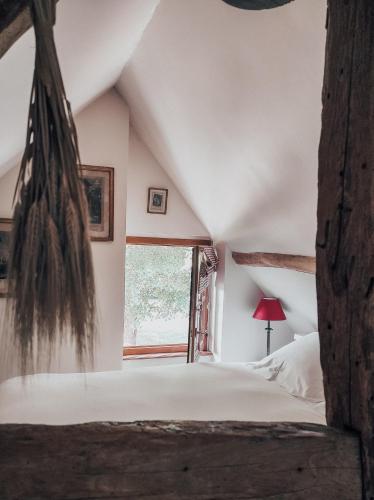 une chambre avec un lit et une fenêtre dans l'établissement Le Relais d'Antoinette, à Prunay-sous-Ablis