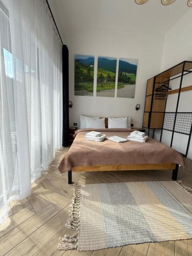 a bedroom with a large bed with white curtains at Шишка in Bukovel