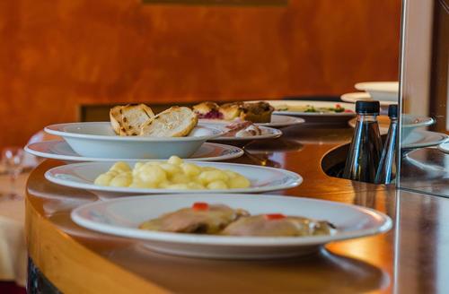 a buffet with plates of food on a table at Hotel Au Soleil in Saint Vincent