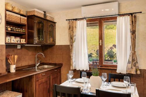 a kitchen with a table with chairs and a window at Herbal Apartment Marjetka in Šentjur