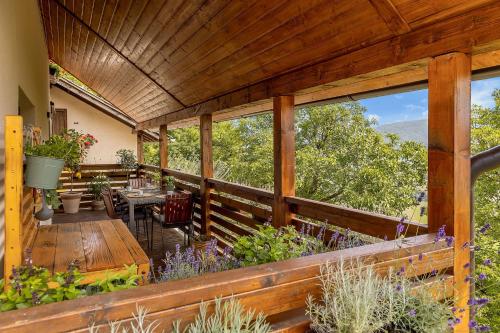 an outdoor deck with a table and chairs and windows at Herbal Apartment Marjetka in Šentjur