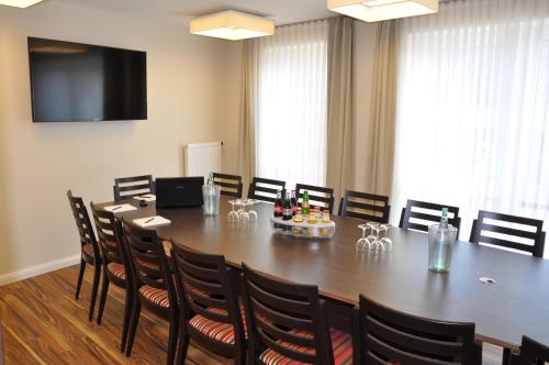 a conference room with a large wooden table and chairs at Hotel Drei Linden in Twist