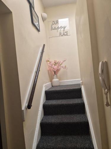 a stairway with a vase with flowers in it at Unique City one bedroom Apartment in the city of Wolverhampton in Wolverhampton