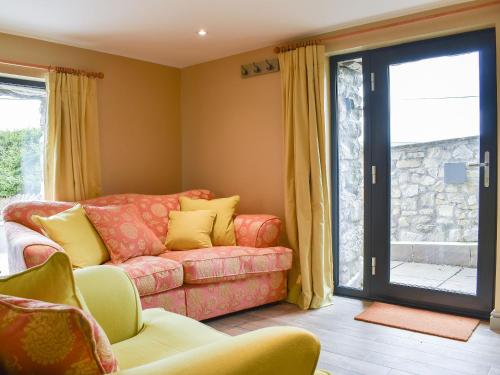 a living room with a couch and a sliding glass door at The Bothy in Beetham