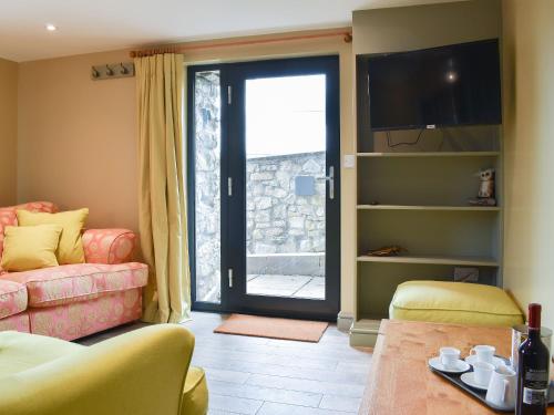 a living room with a couch and a tv at The Bothy in Beetham