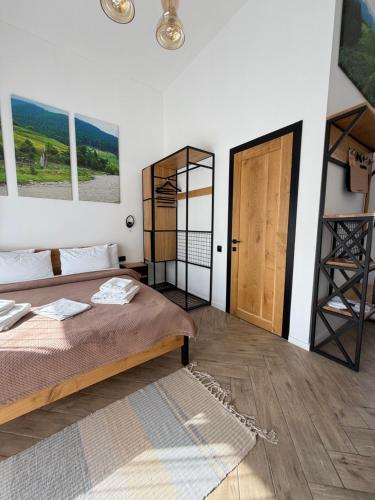 a bedroom with a bed and a wooden door at Шишка in Bukovel