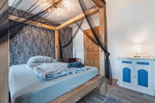 a bedroom with a canopy bed with blue sheets at Zur alten Poststation in Greven