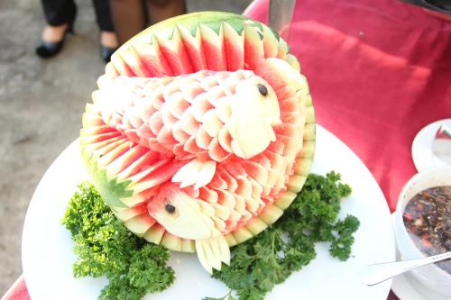 a fruit cake in the shape of a fish on a plate at Aria Gajayana in Malang