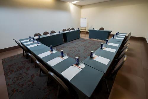 a conference room with long tables and chairs in it at Intercity Vinhedo in Vinhedo
